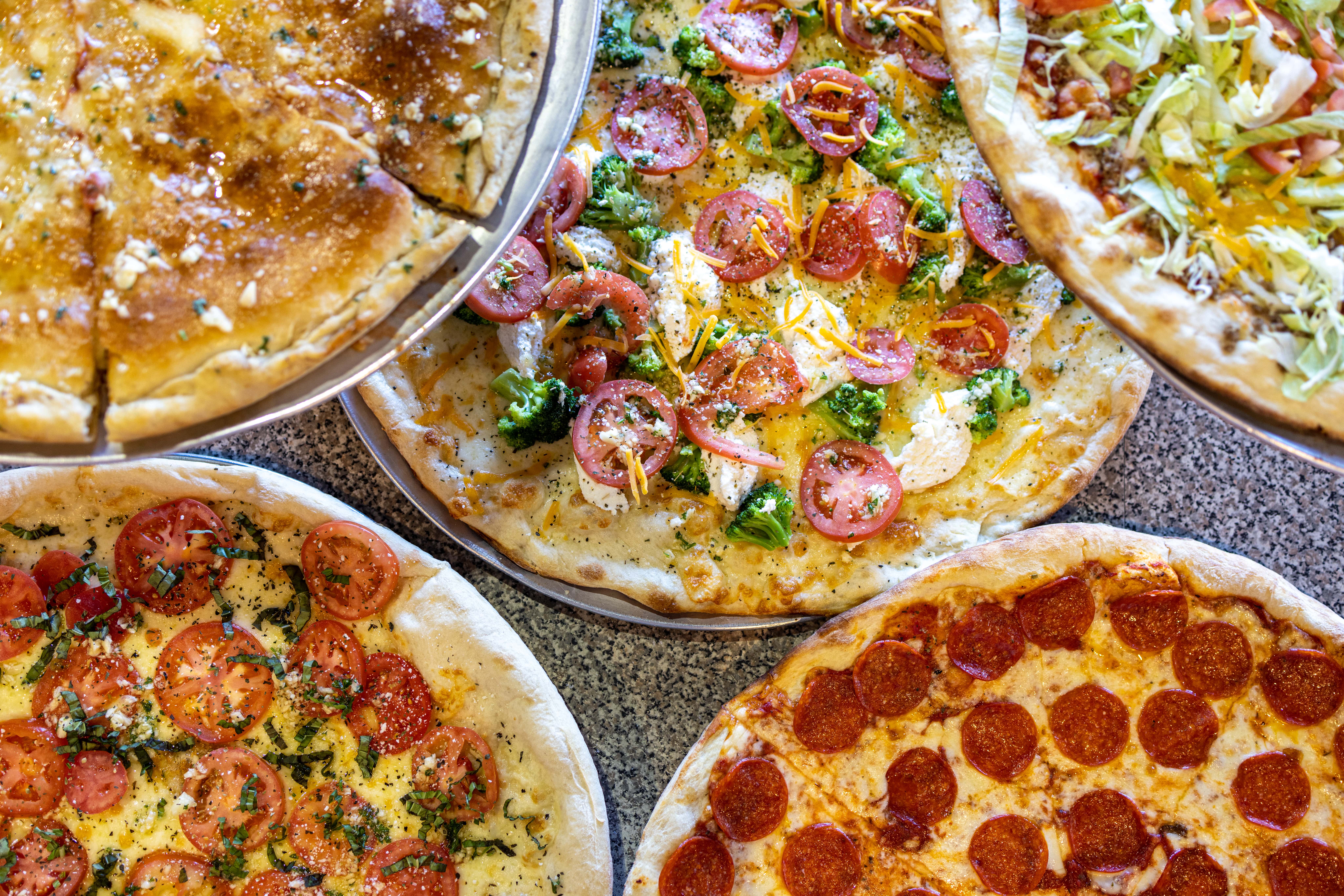 aerial shot of five different pizzas with toppings